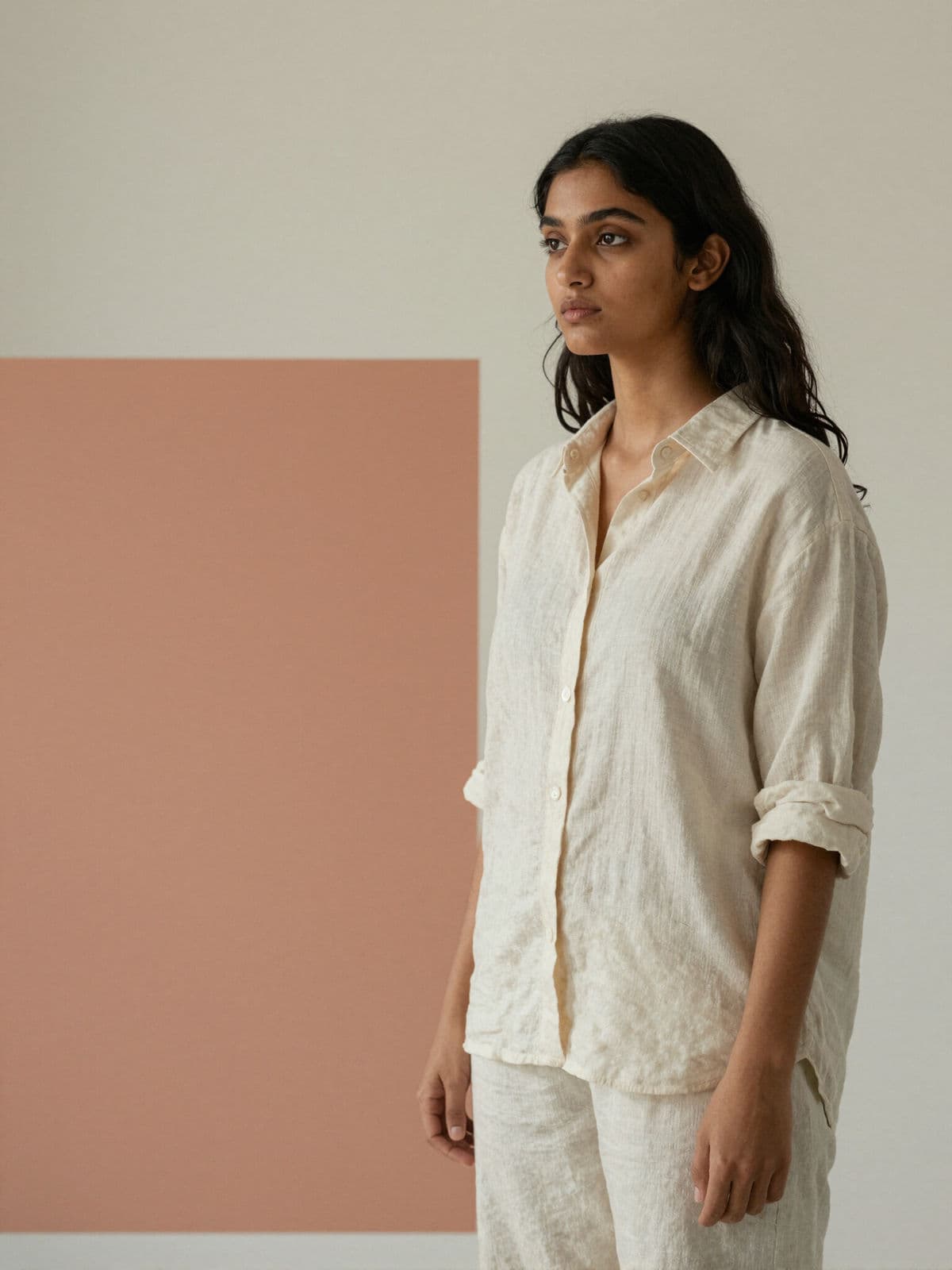 Khyana standing against a terracotta wall